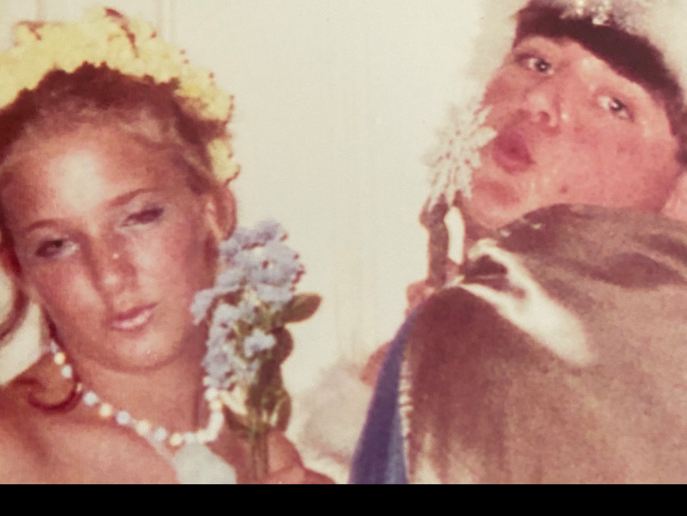 Ellen and Zach Harvey in Halloween costumes. Ellen wears a white dress and yellow flower crown; Zach wears a robe and sparkly crown, grinning at the camera.